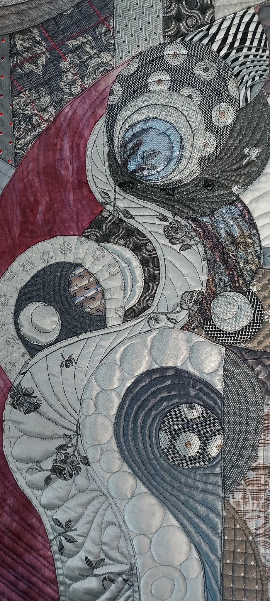 Detail of Galla Grotto’s Amethyst Glow on Silver showing layered fabrics, quilting, intricate stitching and circular abstract forms.