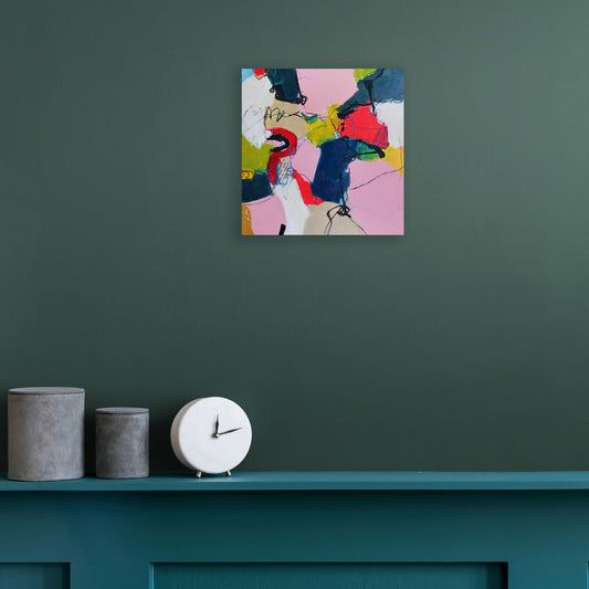 Unexpected by Karen Hammat displayed on a deep green wall above a teal shelf in a contemporary interior.