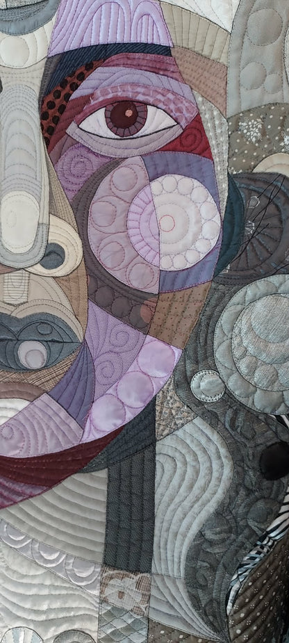Face detail from Amethyst Glow on Silver by Galla Grotto, showing the textile portrait constructed through stitched fabric, pattern and colour.