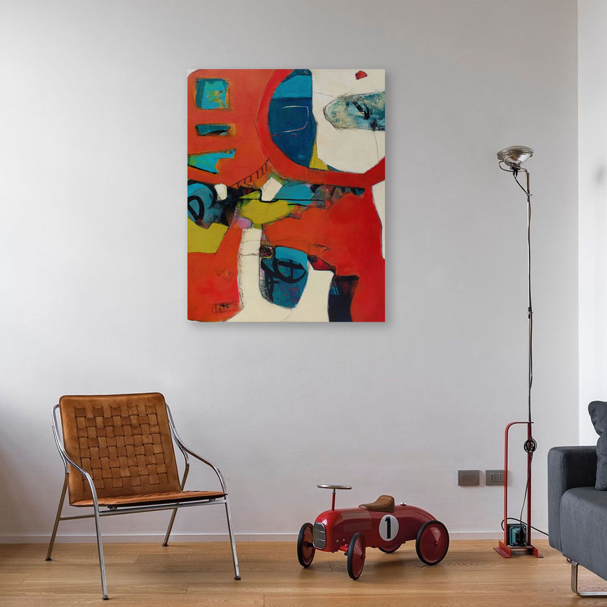 While Rome Burns by Karen Hammat displayed on a white wall in a contemporary interior with a leather chair and red toy car.
