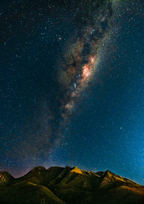Milky Way Over the Outeniquas by Chris Daly, astrophotography landscape of a star-filled night sky and Milky Way above the Outeniqua Mountains, South Africa.