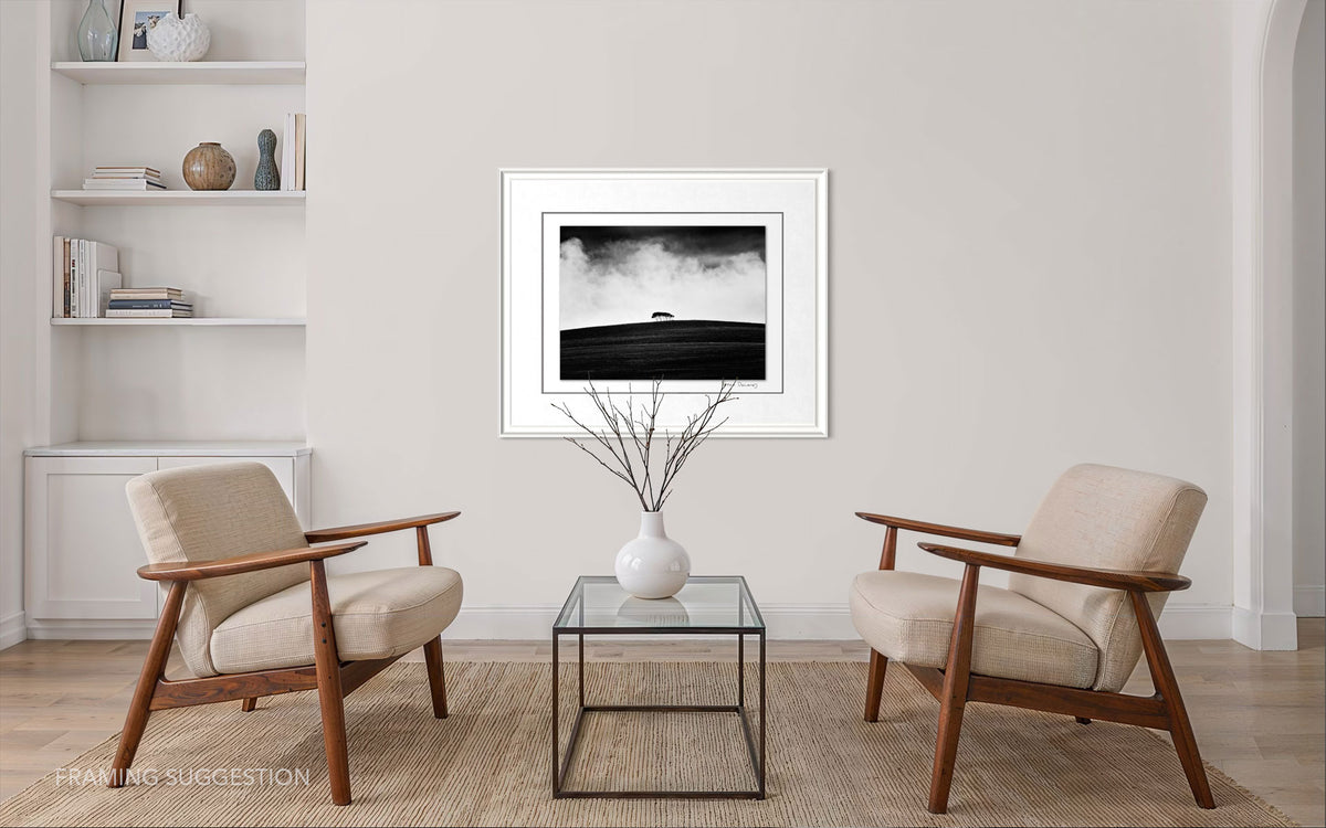 Peter Delaney’s Kareno: The Withered Field framed between two armchairs in a neutral contemporary living room, showing a suggested presentation for the photograph.
