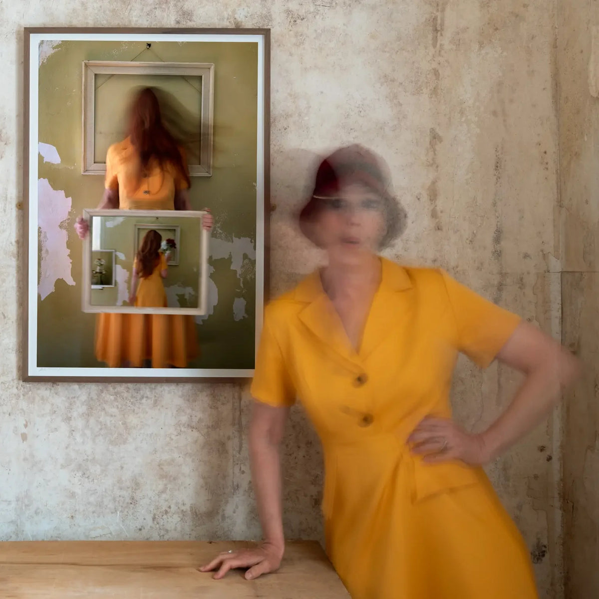 A long-exposure of photographer Robyn Daly standing beside her framed print Portrait In Yellow 
