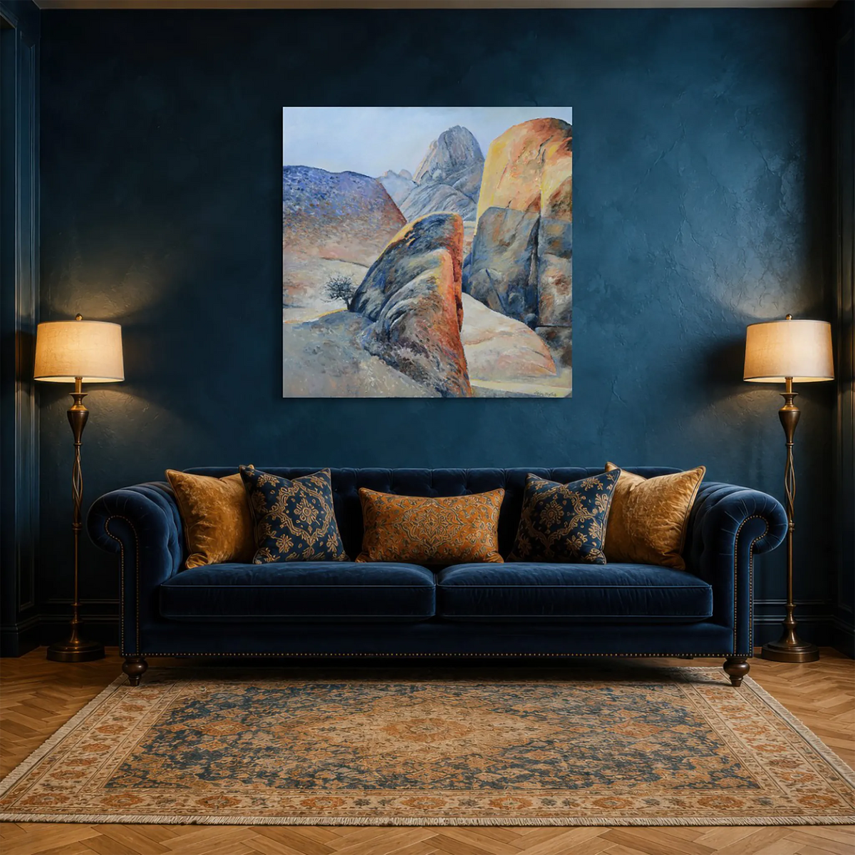 Hein Botha’s Heartland Laid Bare, a colourful contemporary landscape painting of granite rock formations, displayed above a blue velvet sofa in an elegant interior.