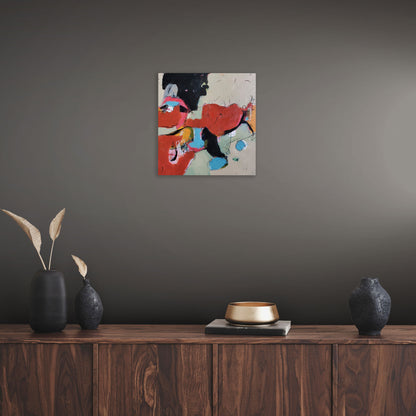 Abstract painting titled Pigments by Karen Hammat displayed on a dark grey wall above a wooden sideboard in a contemporary interior.
